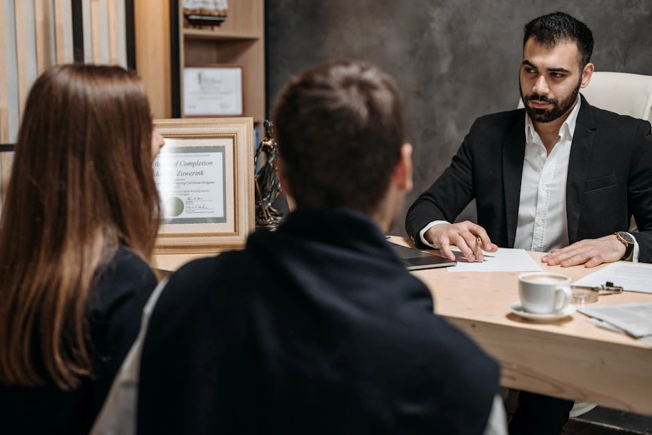 A senior consultant reviewing financial documents with a client in a classic, well-appointed office.
